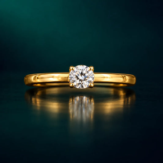 Gold solitaire diamond engagement ring on an emerald background